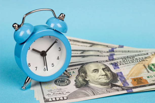 istock money and alarm clock on a blue background 1191731336