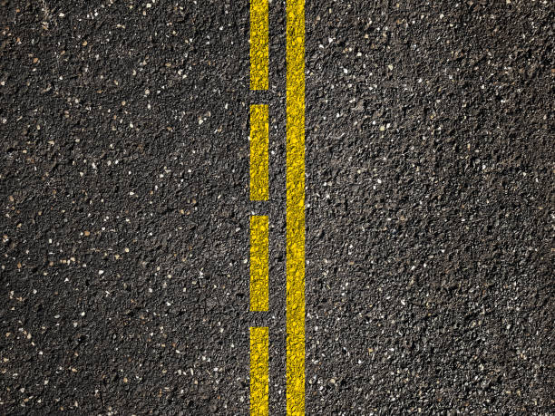 Asphalt road with dividing yellow lines.