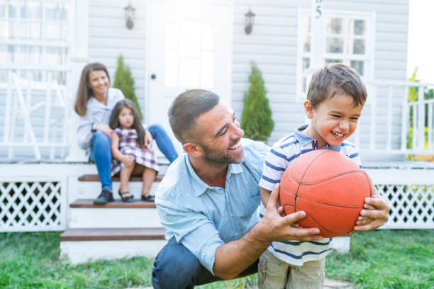 istock Father And Son Playing Basketball in front of front yard 1191735389