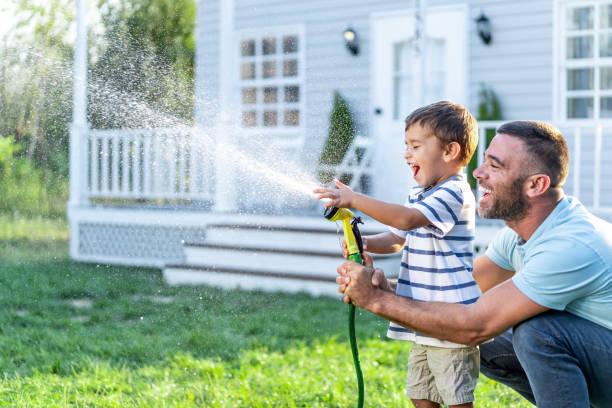 istock Father splashing water and having fun with son on back yard 1191735404