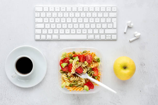 istock Italian pasta with vegetables on office desk with keyboard 1191736316