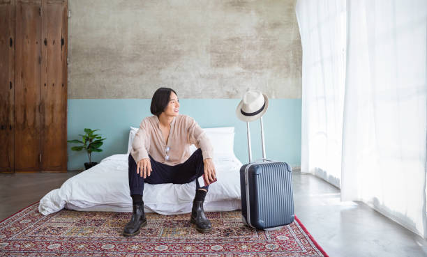 Portrait of young asian man traveler prepare suitcase for holiday vacation. Top overhead view of tourist man lying on bed in hotel room. Asian backpacker travel lifestyle concept banner retrato del joven viajero asiático preparar maleta para vacaciones. vista superior de la parte superior del turista acostado en la cama en la habitación del hotel. pancarta de concepto de estilo de vida de viaje para mochileros asiáticos