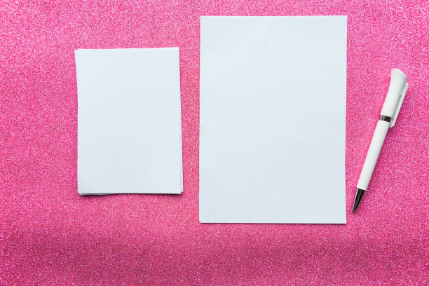 istock Two mockup paper blanks and pen  on pink glitter background 1191740769