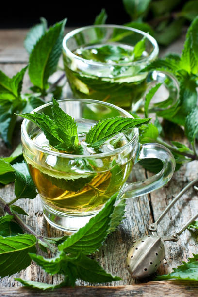 istock Two glass cups with fresh mint tea on wooden table 1191741719