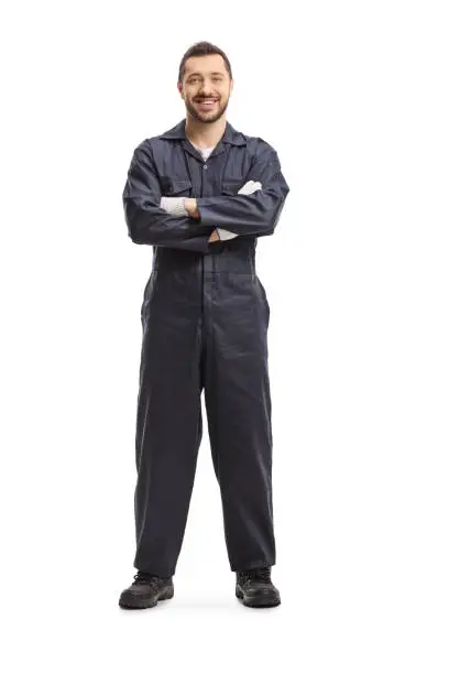 Full length portrait of a mechanic in a dark blue overalls isolated on white background