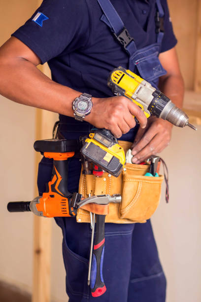 istock Handyman with headphones works with drill does repair. 1191742695