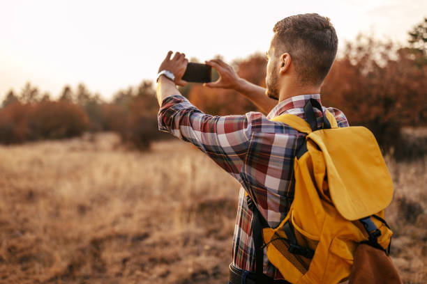 istock Man photographing using phone in nature 1191743216