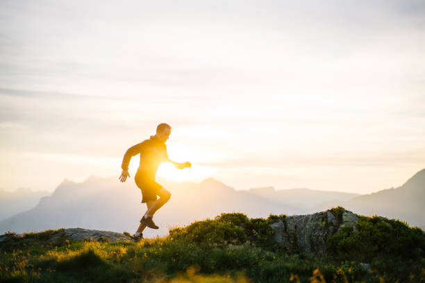 istock Young man runs on mountain ridge at sunrise 1191744231