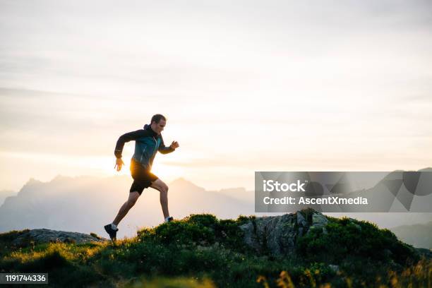 Young Man Runs On Mountain Ridge At Sunrise Stock Photo - Download Image Now - Running, Healthy Lifestyle, Exercising