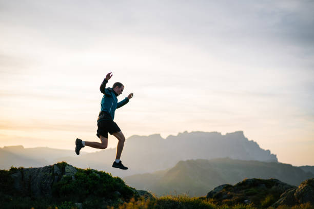 istock Young man runs on mountain ridge at sunrise 1191744339