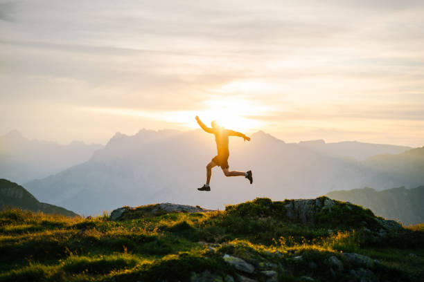 le jeune homme court sur la crête de montagne au lever de soleil - distance running jogging running fog photos et images de collection