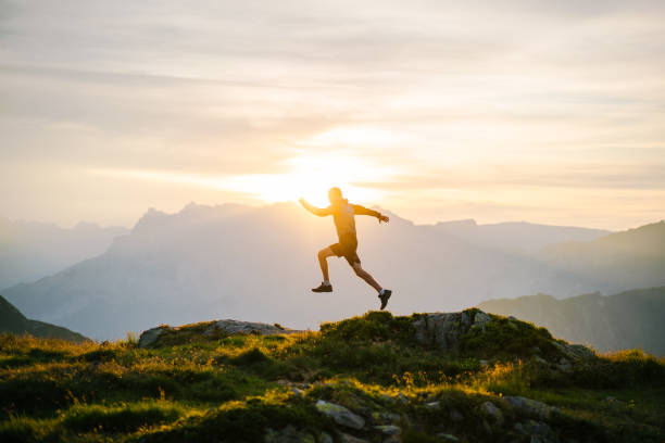 le jeune homme court sur la crête de montagne au lever de soleil - distance running jogging running fog photos et images de collection