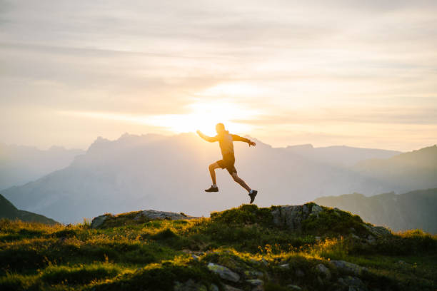 istock Young man runs on mountain ridge at sunrise 1191744408