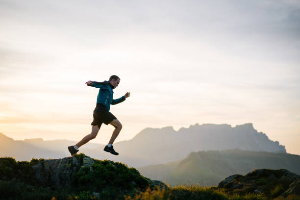 istock Young man runs on mountain ridge at sunrise 1191744409