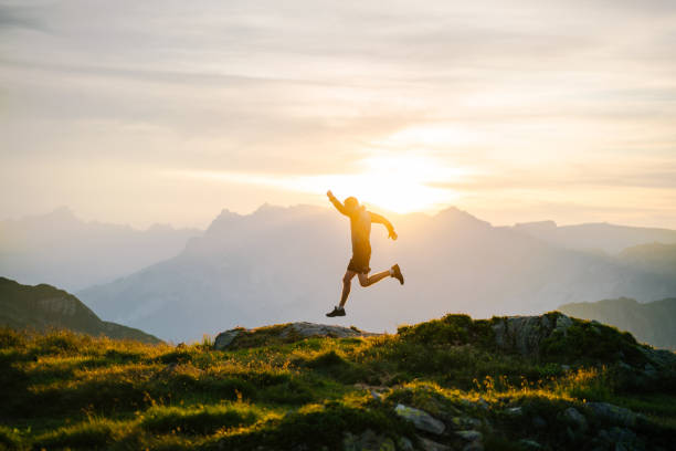 若い男は日の出に山の尾根で走る - running jogging men shoe ストックフォトと画像