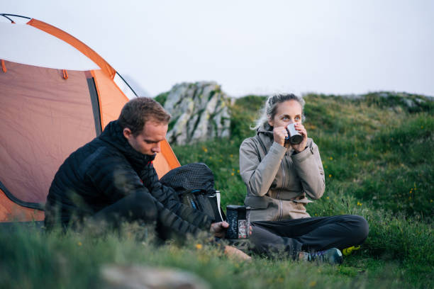 istock Friends relax outside tent at sunrise 1191745328