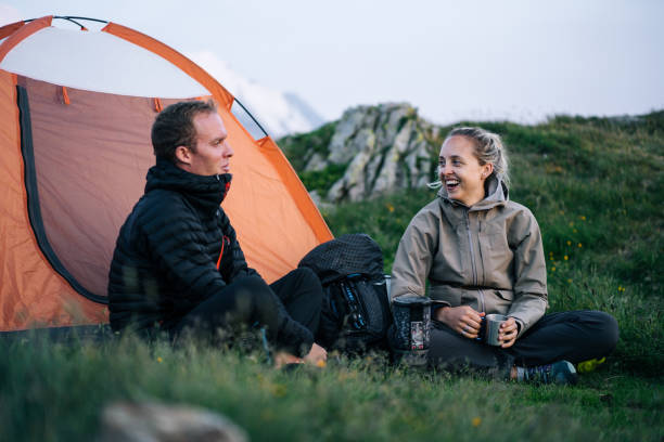 istock Friends relax outside tent at sunrise 1191745405