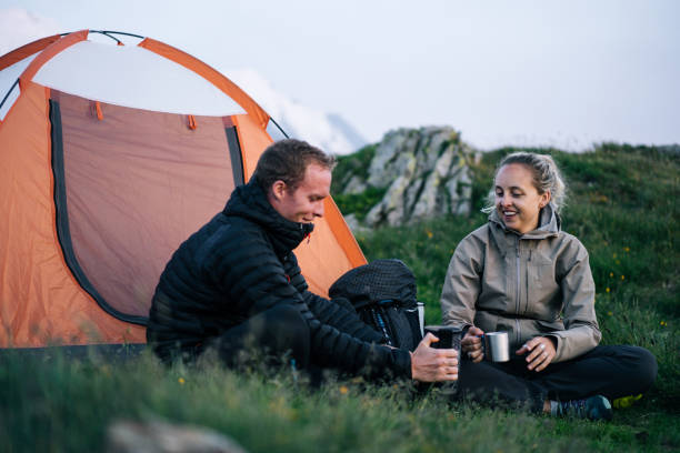 istock Friends relax outside tent at sunrise 1191745521
