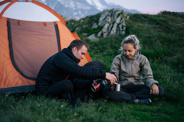 istock Friends relax outside tent at sunrise 1191745527
