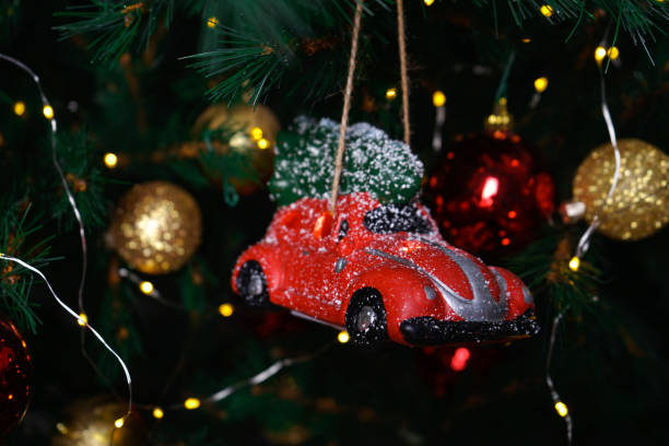 istock Small red car bauble and toys on a Christmas tree. Christmas composition. 1191745646