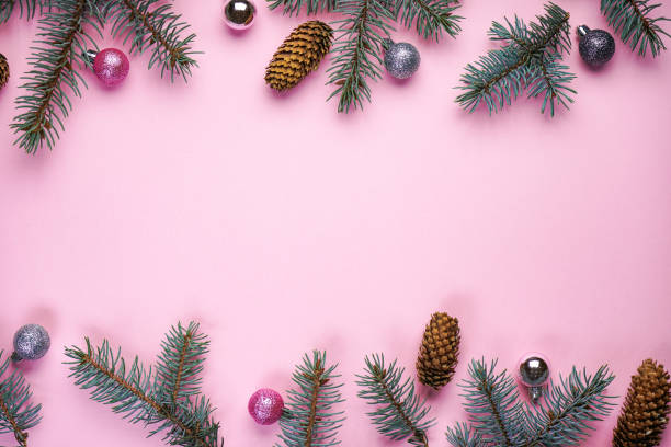 istock Spruce branches with cones and Christmas decorations on a pink background, with space for text, top view. 1191746657