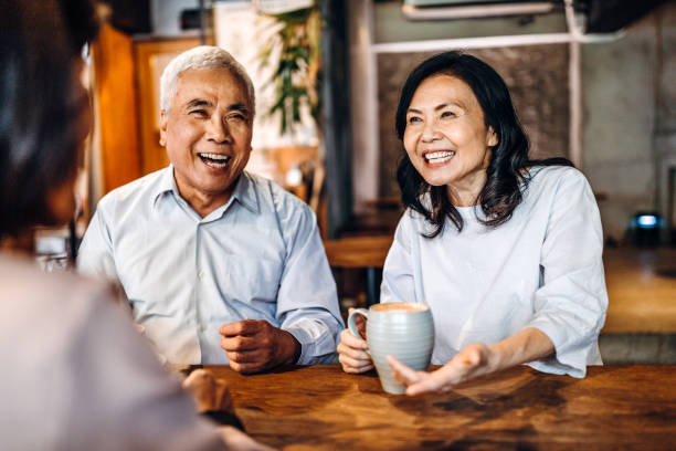 Laughter and happiness is always present when get together Group of three Asian senior friends sitting and talking in cafe, laughing and having fun DisruptAgingCollection stock pictures, royalty-free photos & images