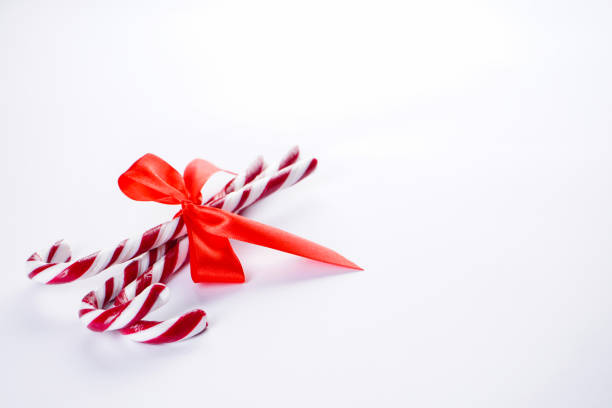istock Christmas concept. Christmas candy with a red bow on a white background. Place for text. 1191750859