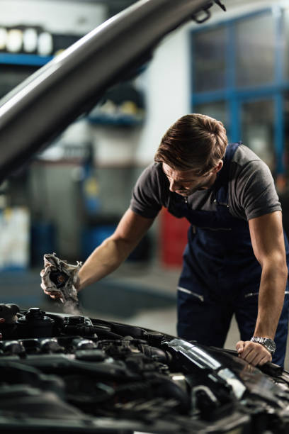 istock Auto mechanic checking overheated car cooling system in a workshop. 1191753305