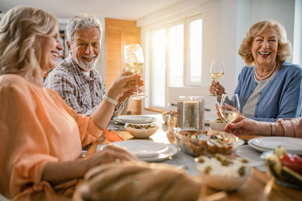 istock Group of cheerful seniors having fun while toasting with wine at dining table. 1191753949