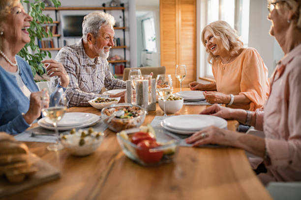 istock Cheerful mature friends communicating during lunch time in dining room. 1191753992