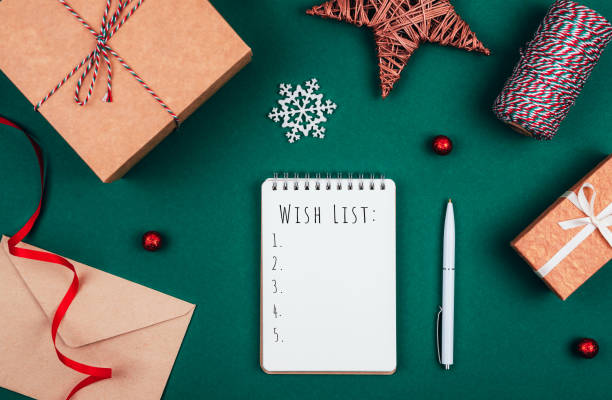 istock Blank notebook, pen, craft gift boxes, envelope,  red bow, ribbon and  decorations over green festive background. 1191754889