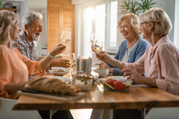 istock Cheerful senior friends toasting with wine at dining table. 1191755023