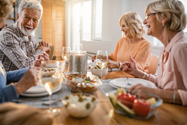 istock Happy seniors enjoying in conversation during lunch time at dining table. 1191757313