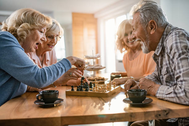 istock Cheerful seniors having fun while playing chess during coffee time at home. 1191760145