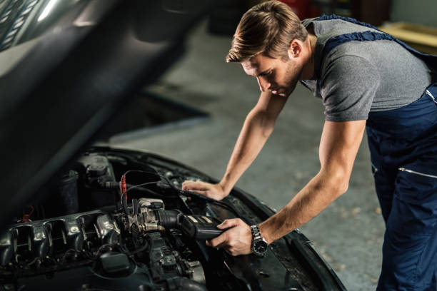 istock Young car mechanic using diagnostic tool while working in auto repair shop. 1191761317