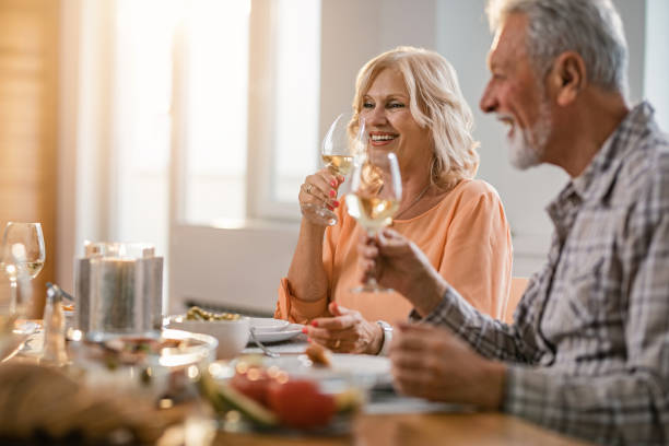 istock Happy mature couple drinking white wine while having lunch at home. 1191762307