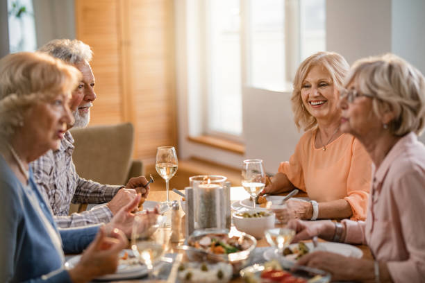 istock Happy mature people communicating while eating together at dining table. 1191762422