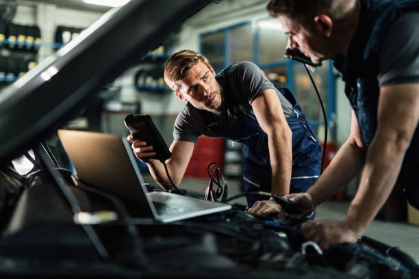 istock Auto mechanics talking while working on car diagnostic in repair shop. 1191765187