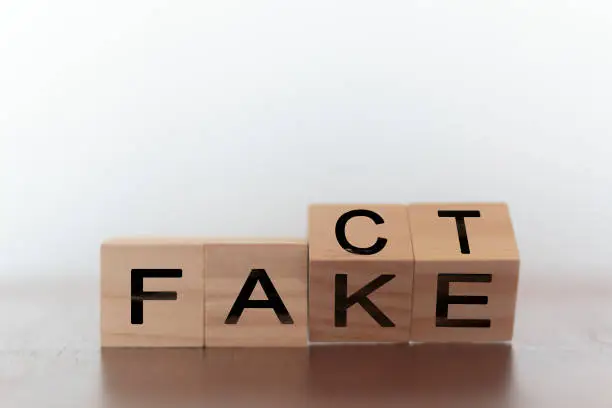 Photo of Fact and fake on words on wooden cubes
