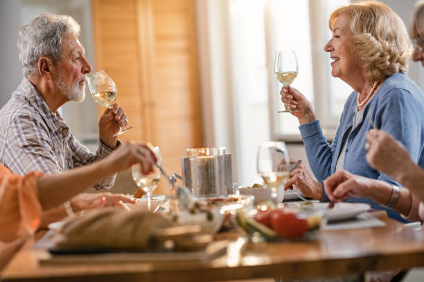 istock Senior couple drinking wine and talking while sitting at dining table. 1191765644