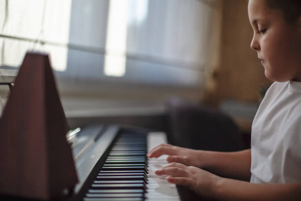 istock Boy playing piano in his room 1191766532