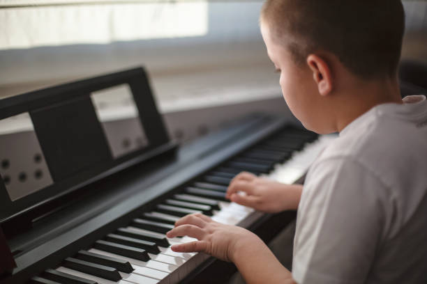 istock Boy playing piano in his room 1191766678
