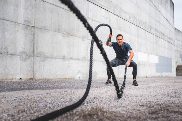 istock Fit Male Athlete Doing Dynamic Workout with Battle Ropes 1191770050