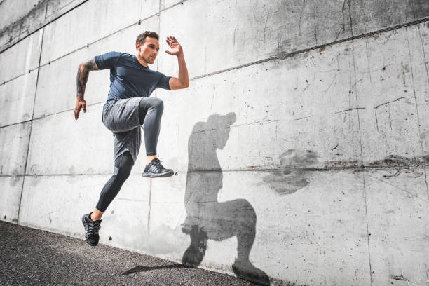 atleta maschio che corre con buona forma e alta azione del ginocchio - strutting foto e immagini stock