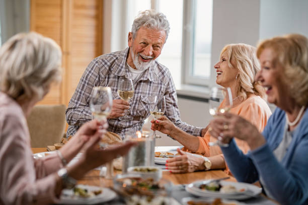 istock Group of happy mature people drinking wine and having fun at dining table. 1191771965