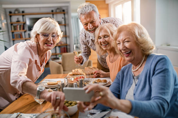 istock Happy senior people taking selfie with smart phone at dining table. 1191774185