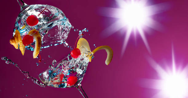 Colorful cocktails in glasses with splashes garnished with lemon and cherries.