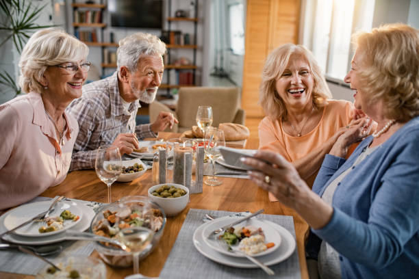 istock Group of cheerful senior friends having fun at dining table. 1191776045