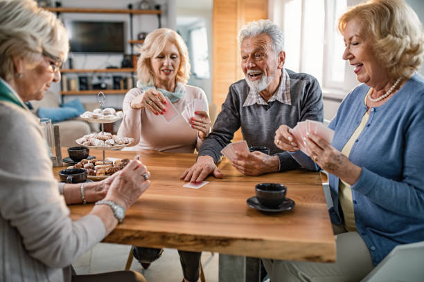 istock Senior man having fun while playing cards with friends at home. 1191781500