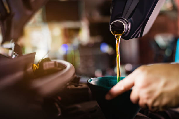 refueling and pouring oil quality into the engine motor car transmission and maintenance gear.energy fuel concept. - motor oil bottle imagens e fotografias de stock